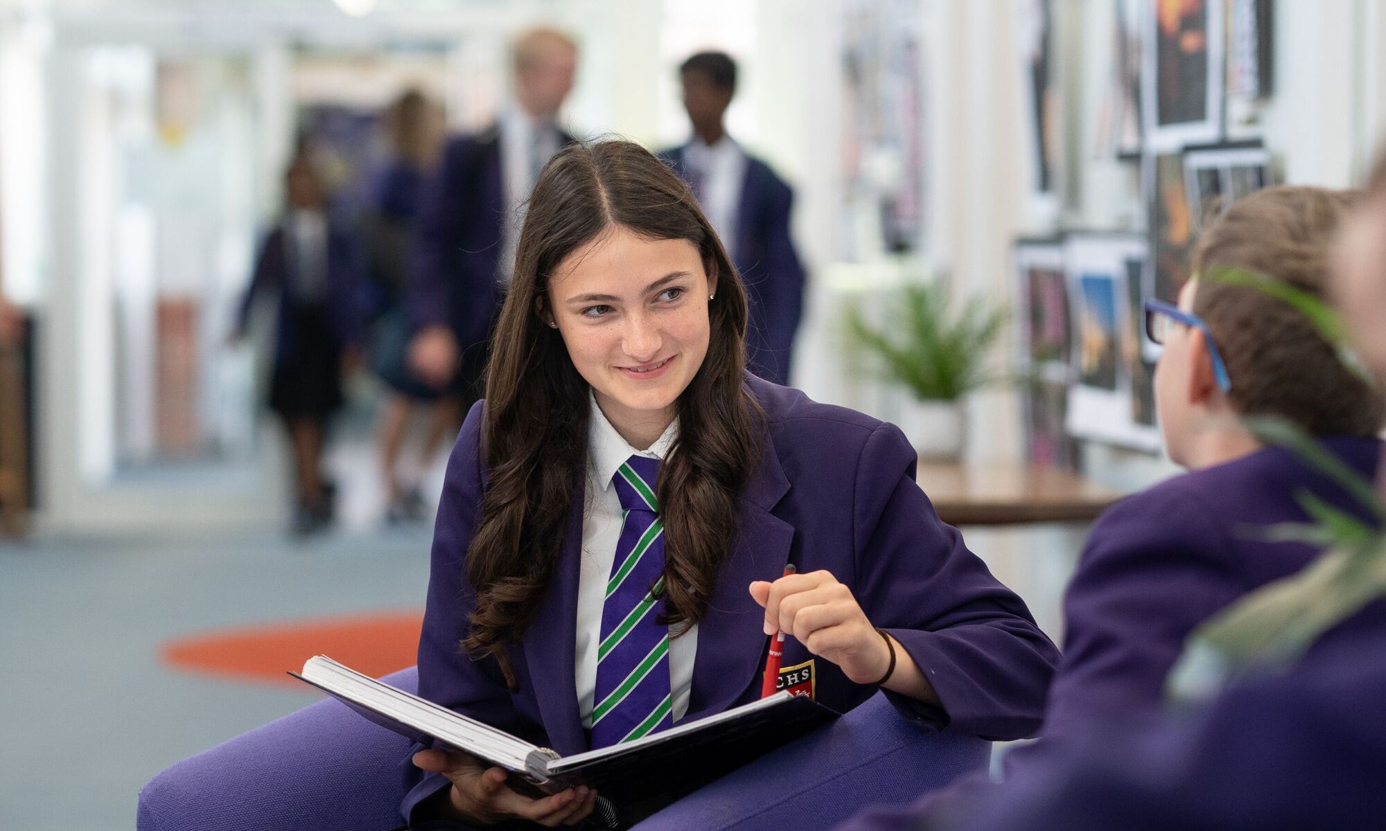 Female student talking to another in the main corridor