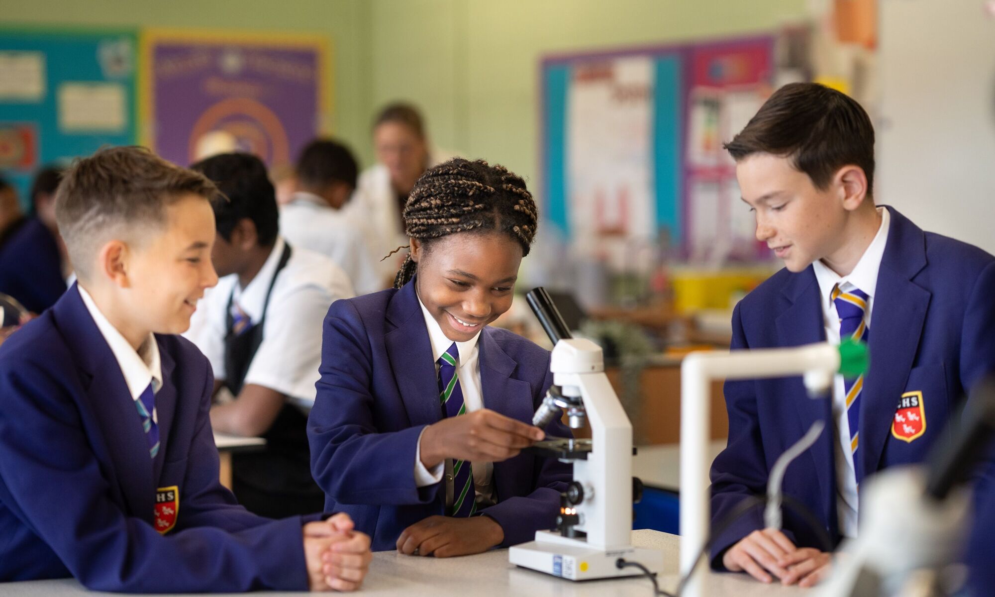 Male and female students with a microscope